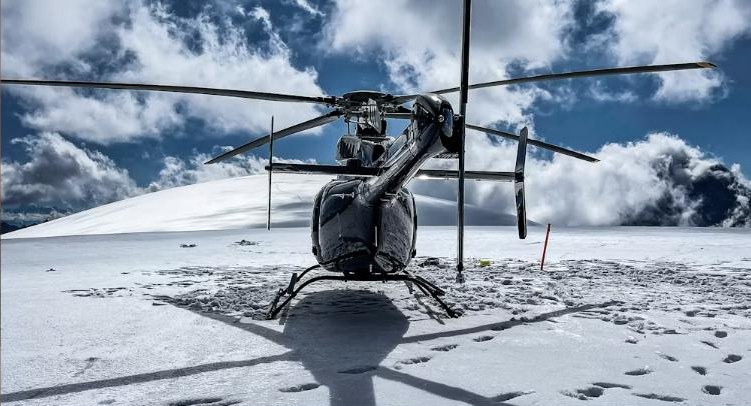 El helicóptero espera en la cima de la montaña